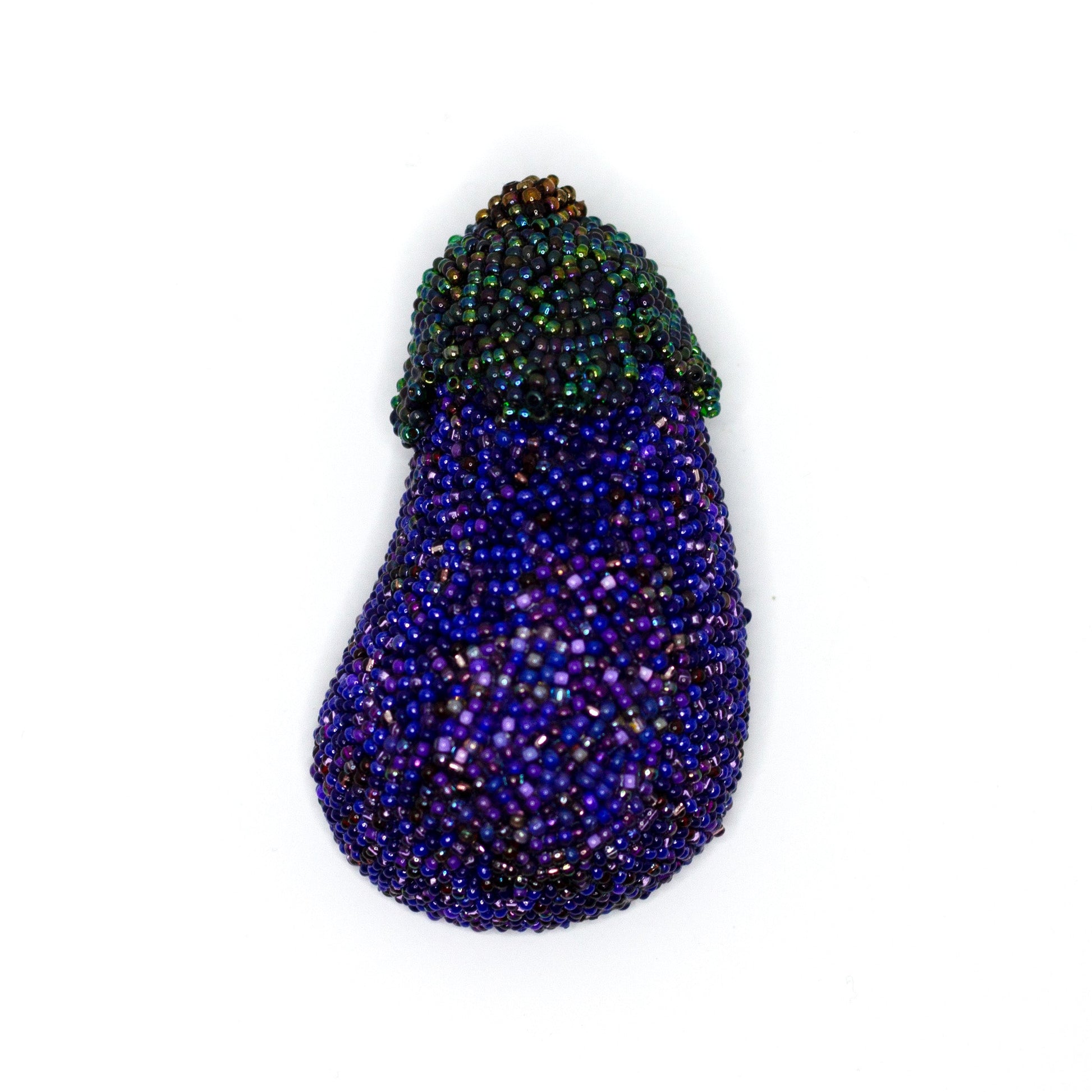Handmade beaded purple eggplant brooch on a white background.