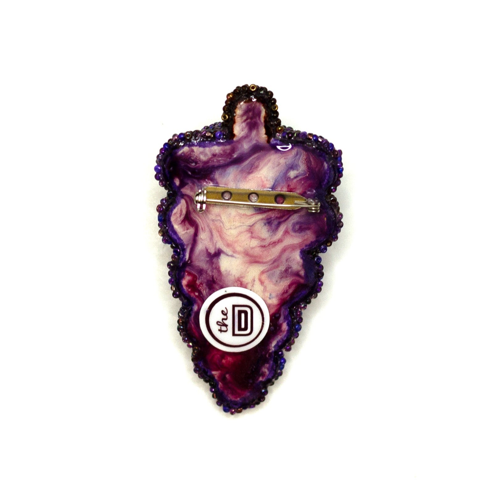 Back view of a purple handmade beaded grape bunch brooch on a white background showing pin fastener.
