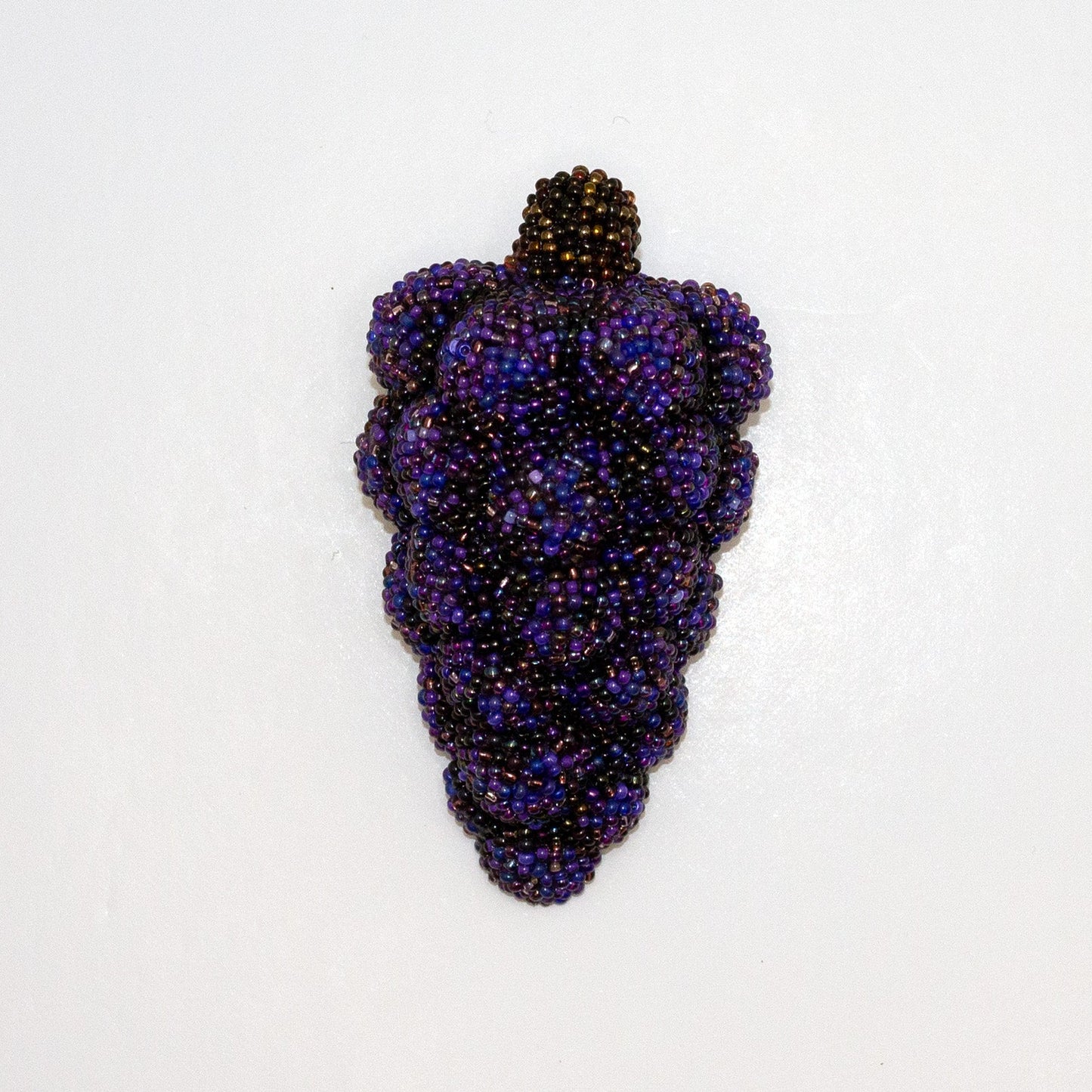 Purple handmade beaded grape bunch brooch shown on a white background.