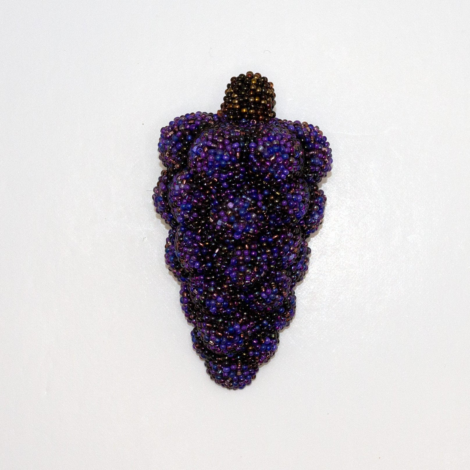 Purple handmade beaded grape bunch brooch shown on a white background.