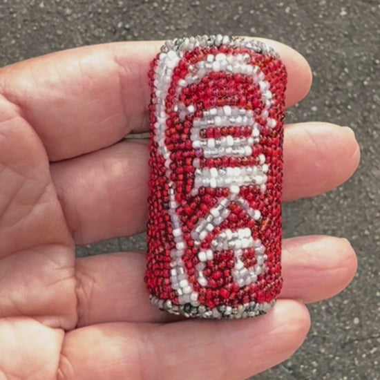 Video of a hand holding a Coke soda pop beaded brooch taken outside to show off the sparkle.