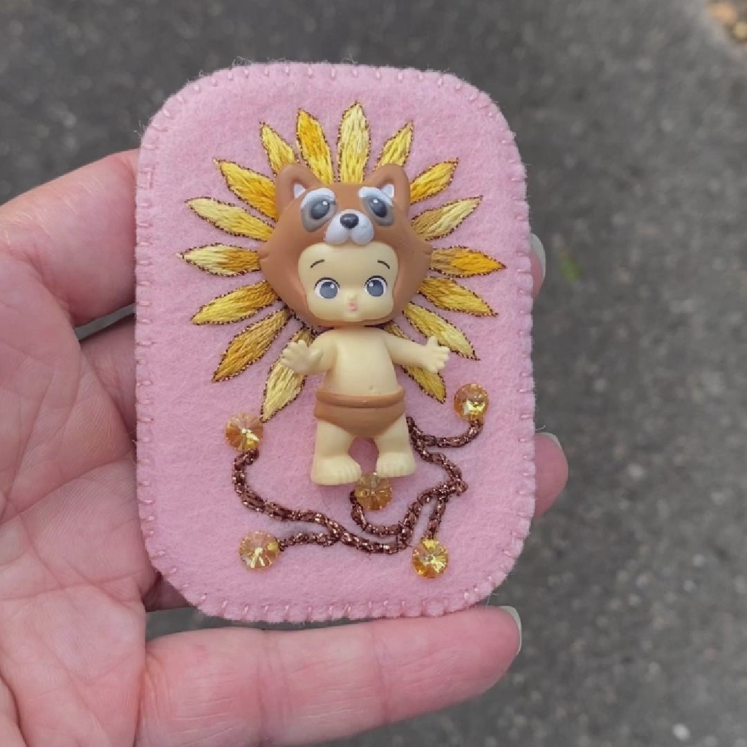 Video of a daisy embroidered brooch with Happi Twozie brooch taken outside to show off the sparkle.