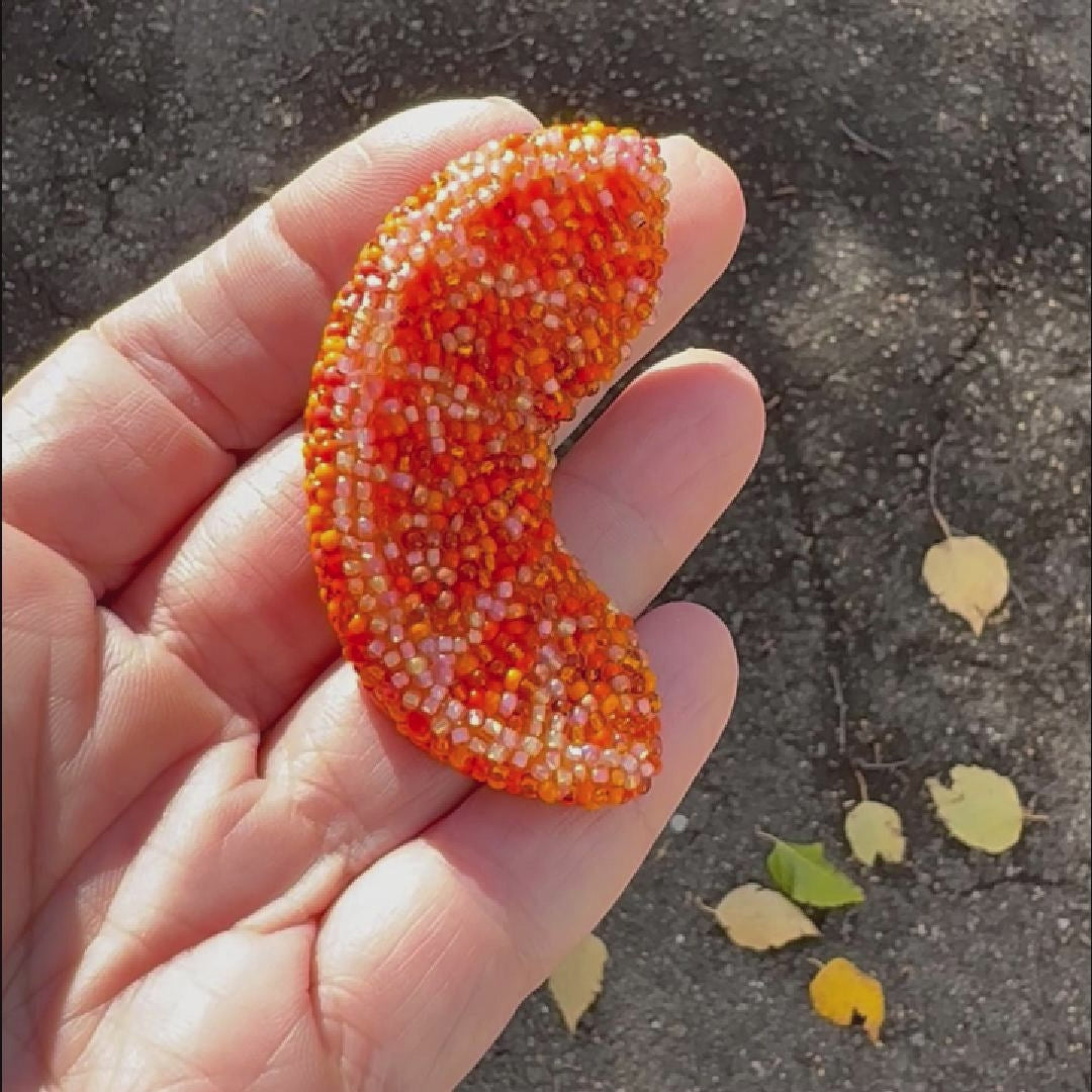 Video of a beaded orange slice brooch taken outside to show off the sparkle.
