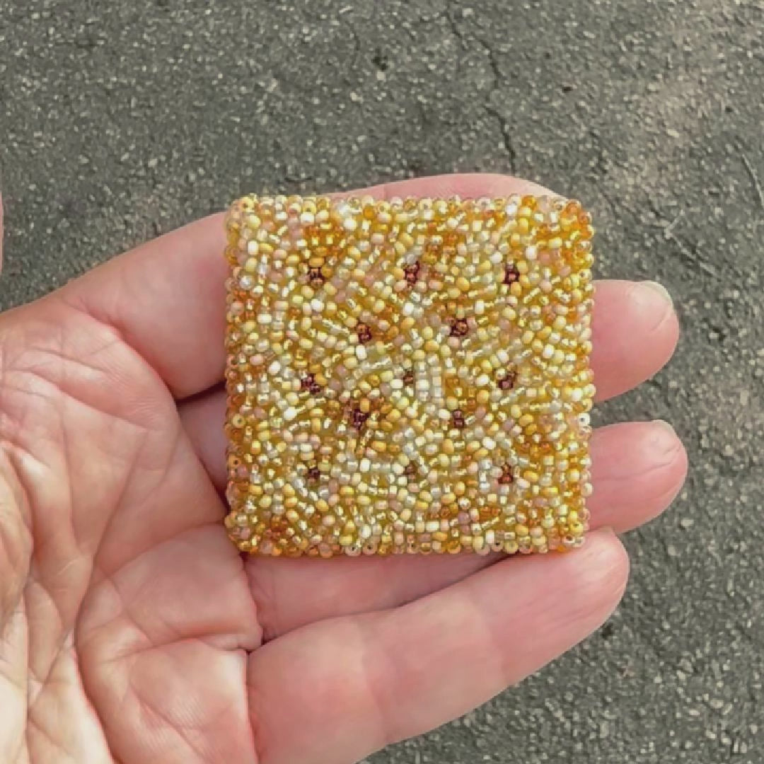 Video showing a beaded square cracker brooch shot in the sunlight to show off the sparkle.