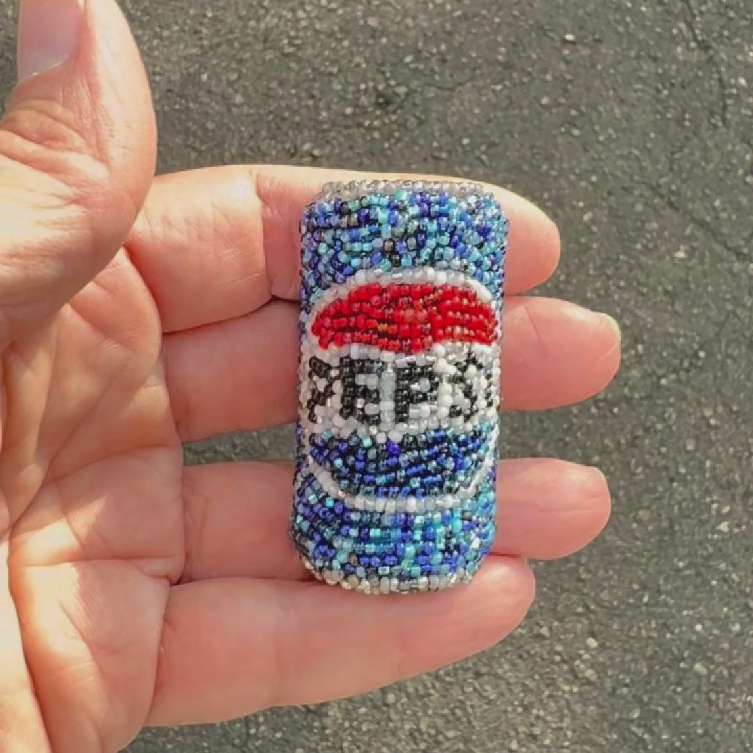 Video showing a beaded Pepsi can brooch  shot outdoors to show off the sparkle.
