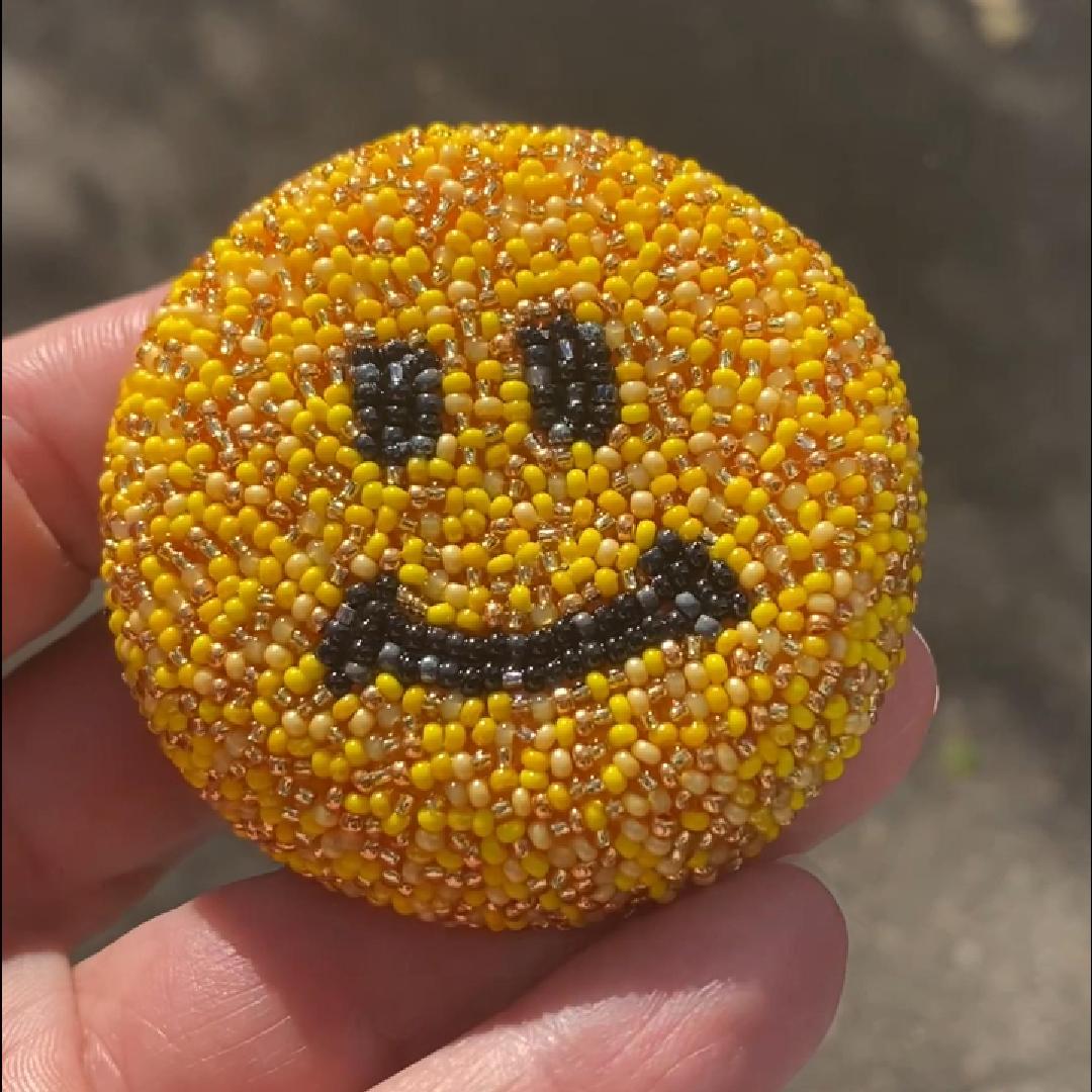 Closeup of a smiley face brooch taken outside to show off the sparkle.