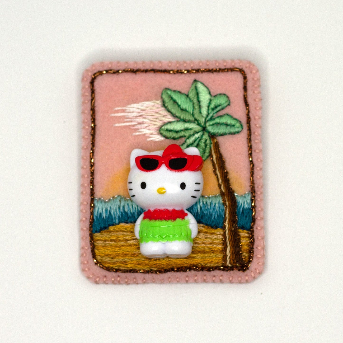 Handmade embroidered Hello Kitty brooch shown on a white background.